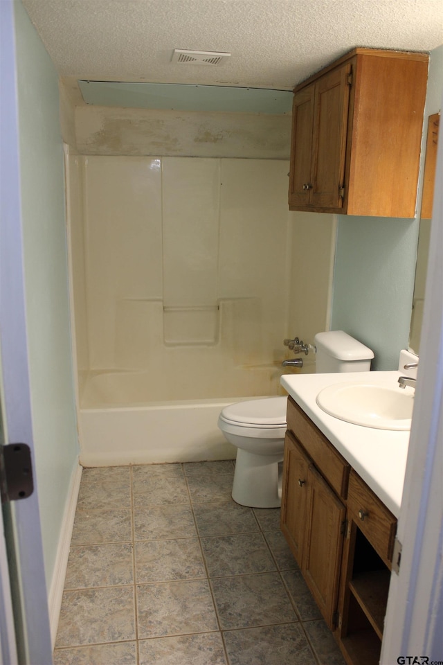 full bathroom featuring vanity, tub / shower combination, a textured ceiling, and toilet