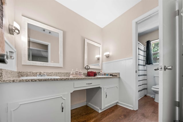 bathroom with tile walls, hardwood / wood-style floors, vanity, and toilet