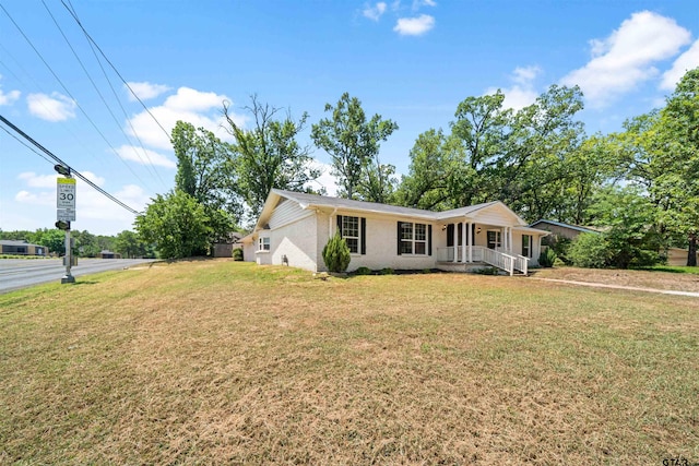 ranch-style home with a front lawn and covered porch