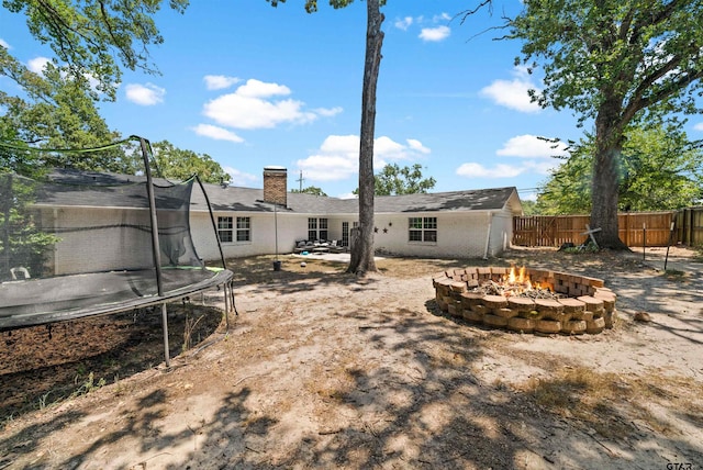 view of yard with a patio area, an outdoor fire pit, and a trampoline