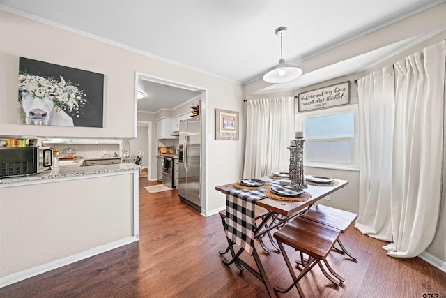 dining room with dark hardwood / wood-style flooring and ornamental molding