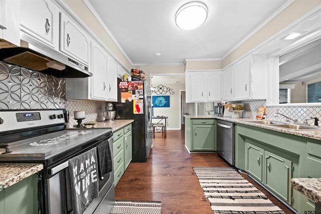 kitchen featuring green cabinets, decorative backsplash, and appliances with stainless steel finishes