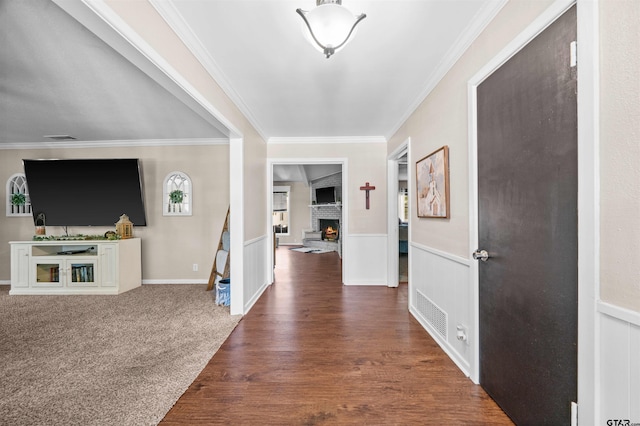 entrance foyer featuring a fireplace, dark hardwood / wood-style floors, and crown molding