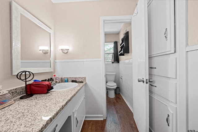 bathroom with hardwood / wood-style floors, vanity, and toilet