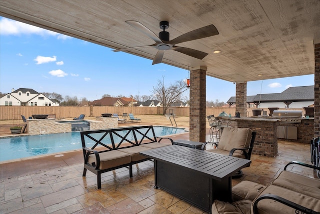 view of patio with exterior bar, pool water feature, outdoor lounge area, an outdoor kitchen, and a grill