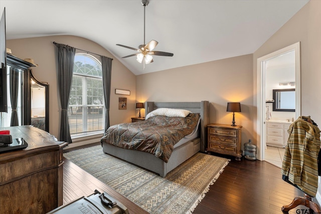 bedroom featuring ceiling fan, ensuite bath, dark hardwood / wood-style floors, and lofted ceiling