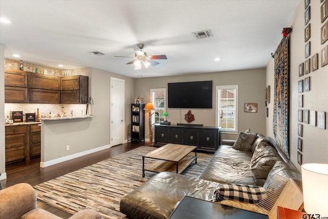 living room featuring dark wood-type flooring and ceiling fan