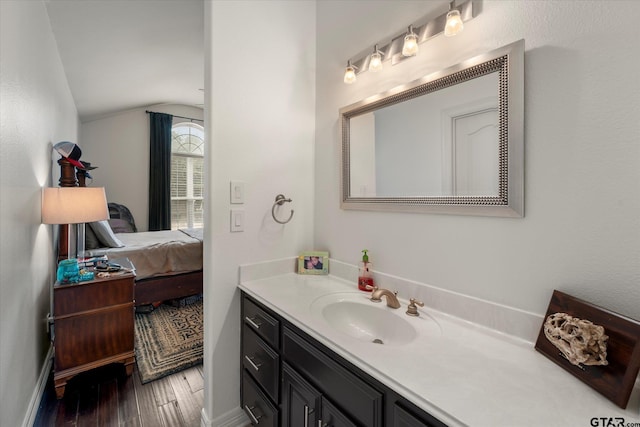 bathroom featuring vaulted ceiling, hardwood / wood-style floors, and vanity