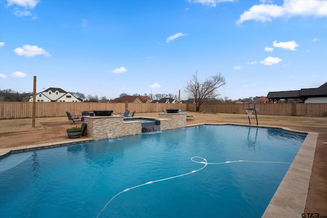 view of pool with pool water feature, an outdoor kitchen, an outdoor bar, and a patio area