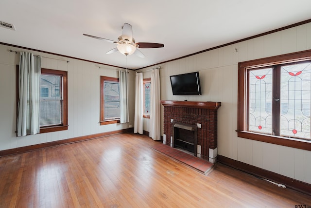 living area with visible vents, wood-type flooring, a ceiling fan, and crown molding