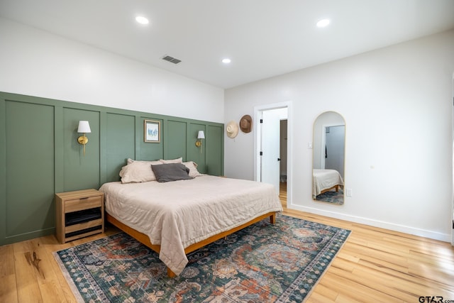 15683 Crk 472, Tyler, TX 75706 - bedroom with a decorative wall, light wood-style flooring, recessed lighting, arched walkways, and a wainscoted wall