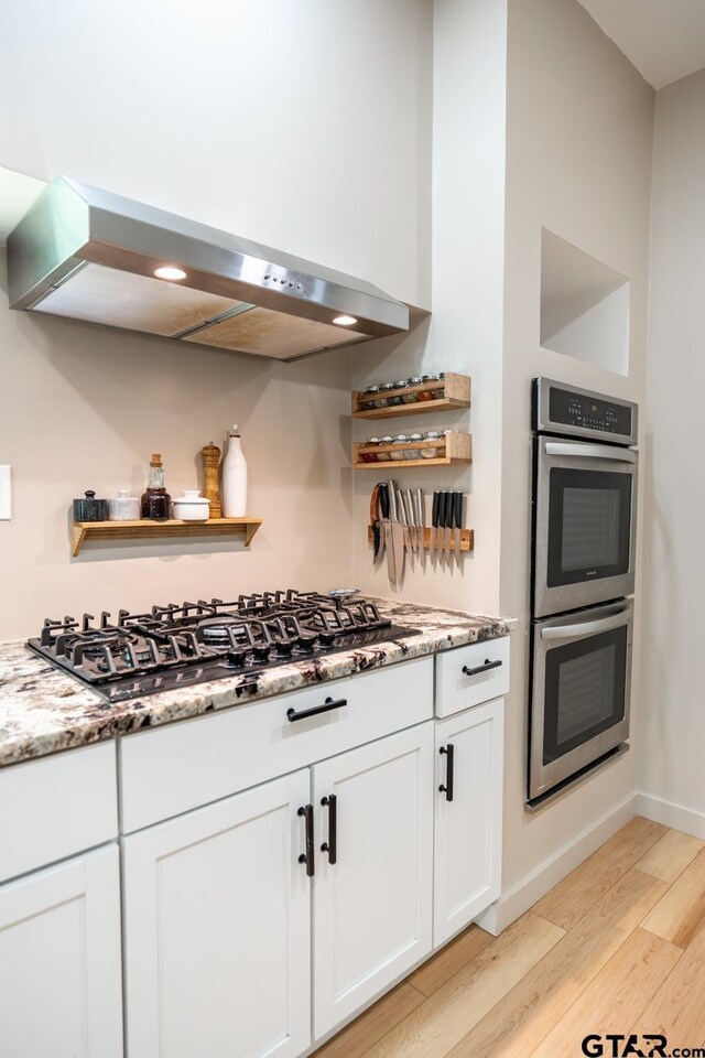 15683 Crk 472, Tyler, TX 75706 - kitchen with stainless steel double oven, light wood finished floors, black gas stovetop, and open shelves