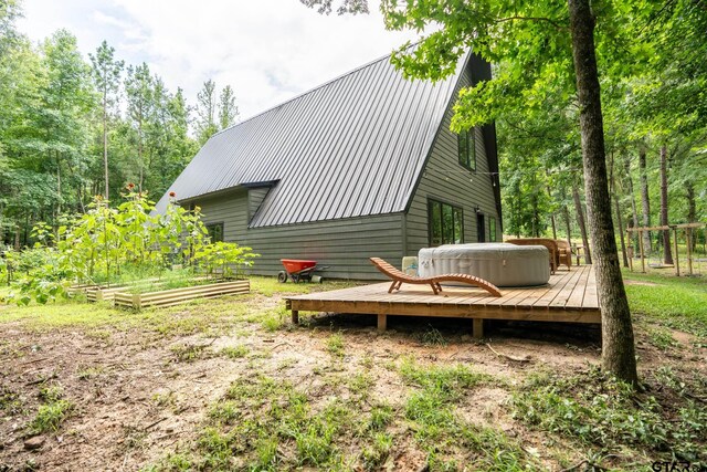 15683 Crk 472, Tyler, TX 75706 - rear view of property featuring a hot tub, a deck, a vegetable garden, and a metal roof