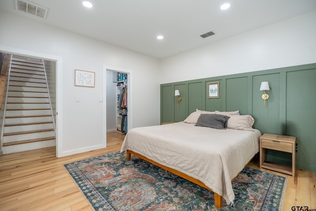 15683 Crk 472, Tyler, TX 75706 - bedroom featuring a decorative wall, a spacious closet, light wood finished floors, recessed lighting, and a closet