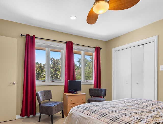 bedroom with a closet, light colored carpet, and ceiling fan