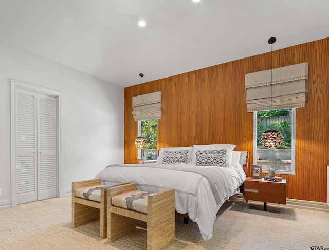 bedroom with wooden walls, a closet, and carpet