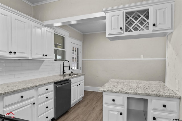 kitchen with stainless steel dishwasher, ornamental molding, sink, wood-type flooring, and white cabinets