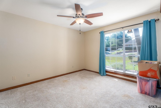 carpeted empty room featuring a wealth of natural light and ceiling fan