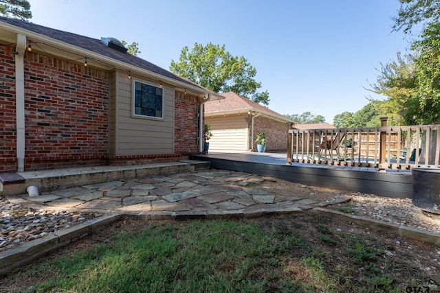 view of side of property with a deck and a patio