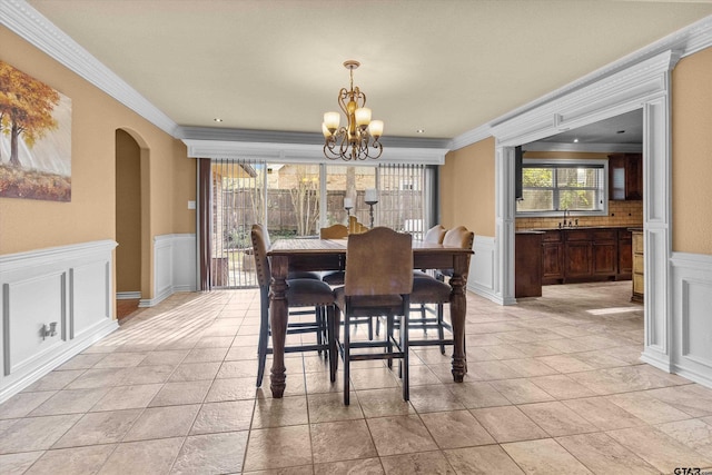 dining room with a chandelier, ornamental molding, and sink