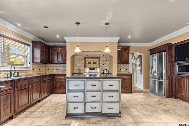 kitchen featuring sink, hanging light fixtures, decorative backsplash, ornamental molding, and stainless steel appliances