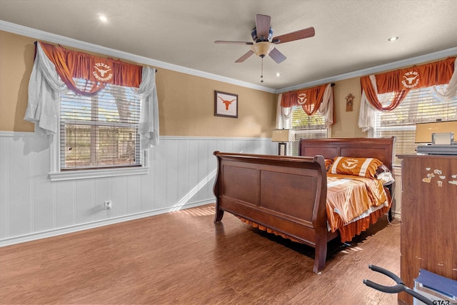 bedroom featuring hardwood / wood-style floors, ceiling fan, and ornamental molding