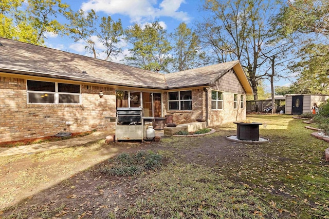 back of house with a yard and a storage shed