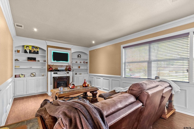 living room featuring a textured ceiling, hardwood / wood-style flooring, built in features, and crown molding