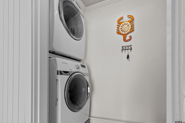 laundry area featuring crown molding and stacked washing maching and dryer