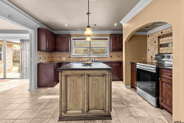 kitchen featuring stainless steel range with electric cooktop, hanging light fixtures, decorative backsplash, ornamental molding, and a kitchen island