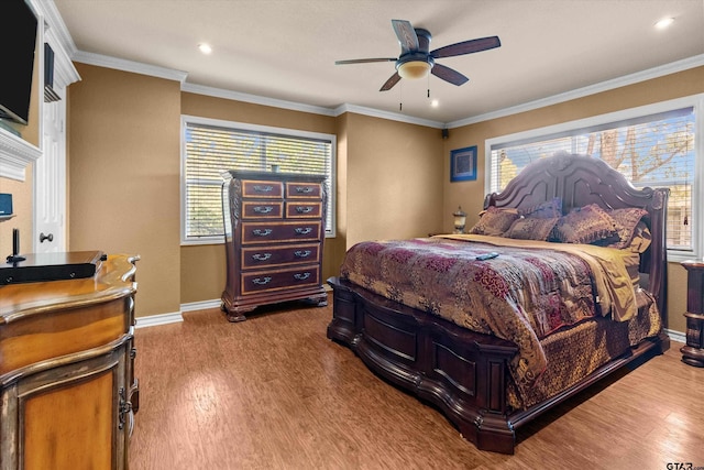 bedroom with hardwood / wood-style flooring, ceiling fan, crown molding, and multiple windows