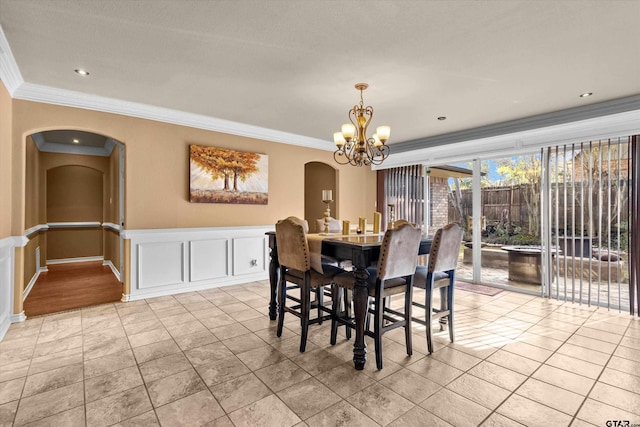 dining space with crown molding and a chandelier