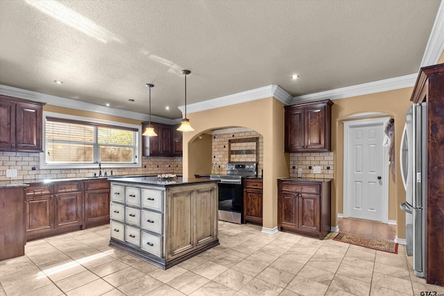 kitchen with pendant lighting, a center island, stainless steel appliances, and crown molding