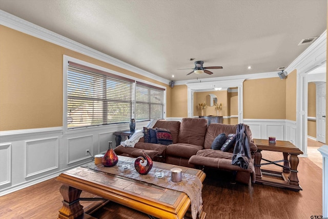 living room with ceiling fan, wood-type flooring, and ornamental molding