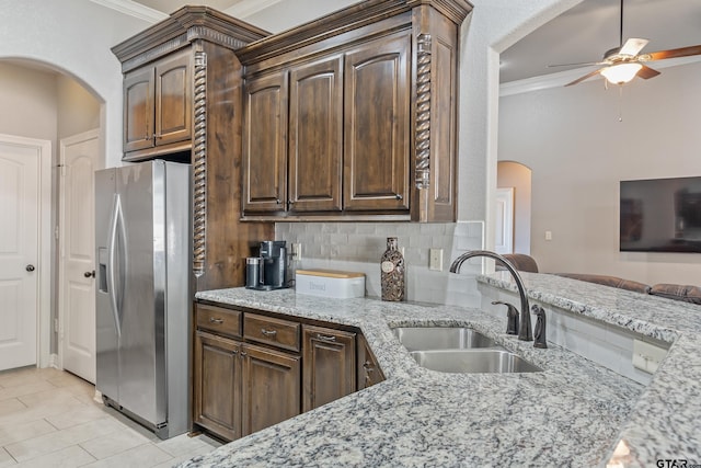 kitchen featuring light stone countertops, tasteful backsplash, stainless steel fridge with ice dispenser, sink, and ornamental molding