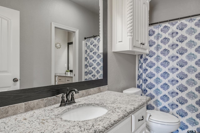 bathroom featuring toilet and vanity