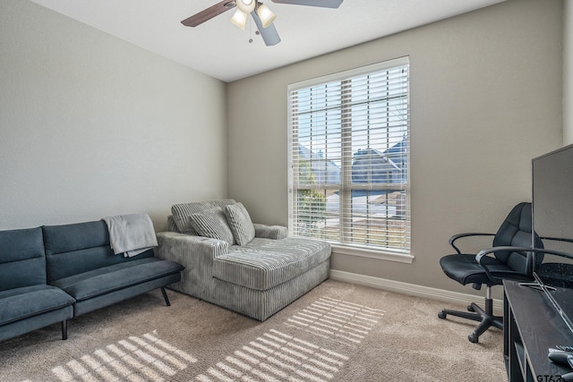 carpeted office space featuring ceiling fan