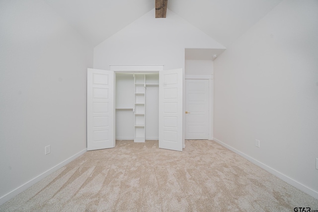 unfurnished bedroom with lofted ceiling with beams, carpet flooring, baseboards, and a closet
