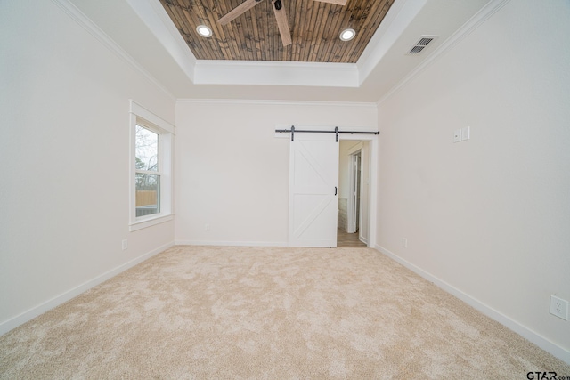 carpeted empty room featuring baseboards, ornamental molding, visible vents, wood ceiling, and a raised ceiling