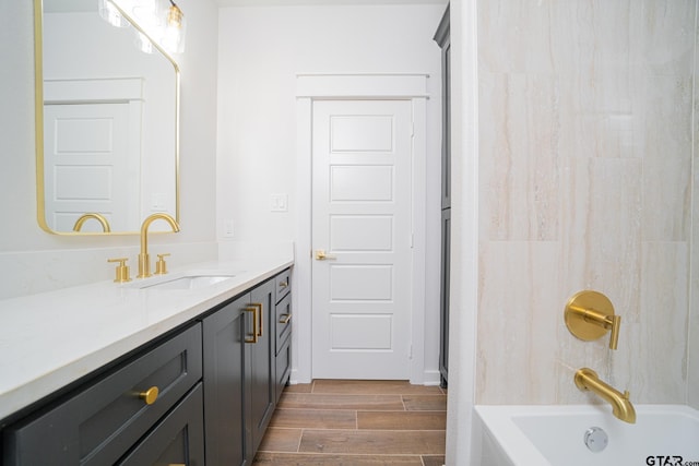 bathroom featuring vanity,  shower combination, and wood finished floors