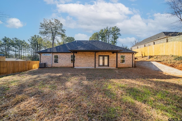 back of house with central air condition unit, brick siding, french doors, and a fenced backyard