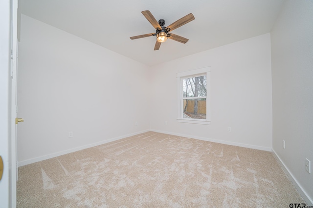 empty room featuring carpet flooring, baseboards, and a ceiling fan