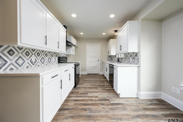 kitchen featuring recessed lighting, backsplash, wall chimney range hood, light countertops, and black appliances