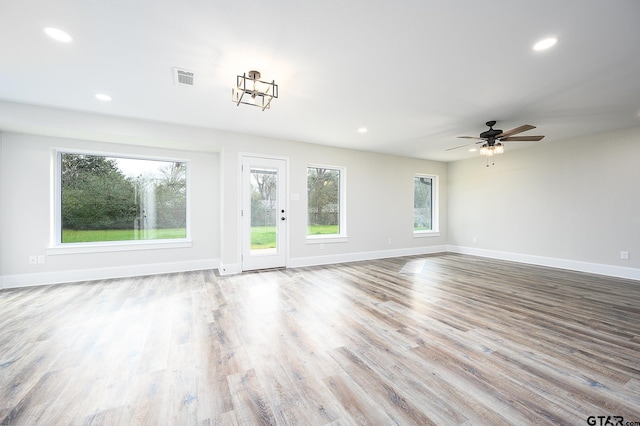unfurnished living room with baseboards, wood finished floors, and recessed lighting