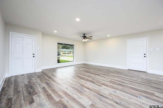 unfurnished living room featuring recessed lighting, wood finished floors, a ceiling fan, and baseboards