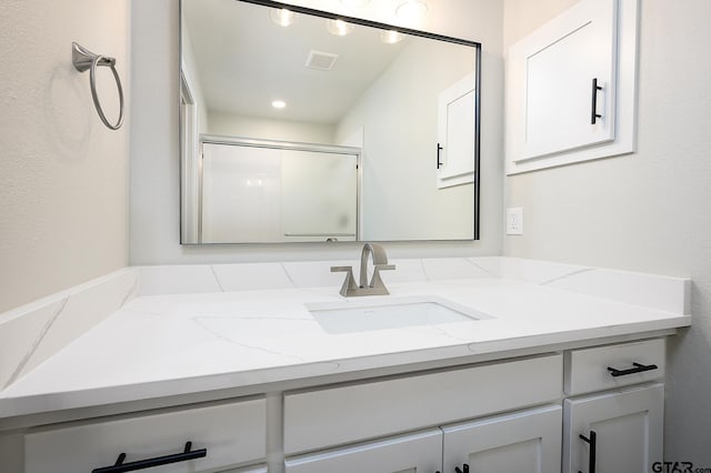 full bathroom featuring visible vents, vanity, and an enclosed shower