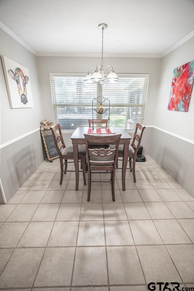 tiled dining space featuring plenty of natural light, a notable chandelier, and crown molding