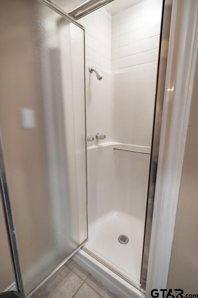 bathroom with tile patterned flooring and a shower