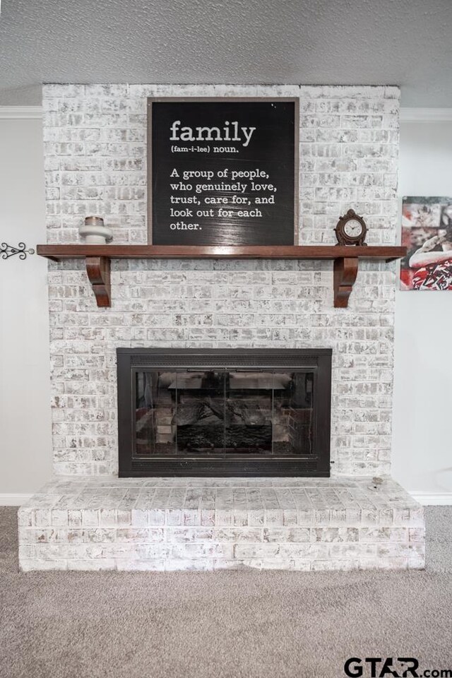 interior details featuring crown molding, a textured ceiling, a brick fireplace, and carpet floors