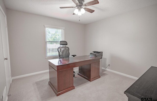 home office with a textured ceiling and light carpet